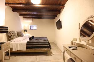 a bedroom with a bed and a vanity and a mirror at Semantron Traditional Village in Diakopto