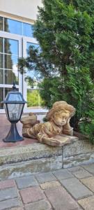 a statue of a lion sitting in front of a building at Villa Klavia in Zatoka
