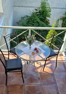 a glass table and two chairs on a balcony at Villa Klavia in Zatoka