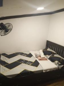 a bed with a quilt on it in a room at Su Staycation Minimalist in Naic