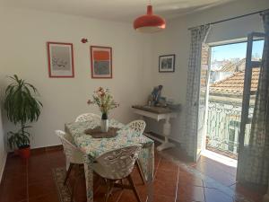 a dining room with a table and chairs and a window at Central Tavira apartment, Casa Oliverio in Tavira