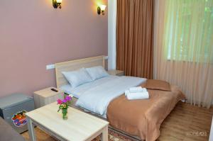 a small bedroom with a bed and a table at Narek Home Goris in Harzhis