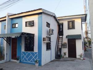 a blue and white building with a ladder in front at Su Staycation Minimalist in Naic