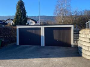a pair of garage doors in a driveway at Bell air Max in Les Hauts-Geneveys