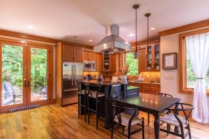 a kitchen with wooden cabinets and a black island with chairs at Headwaters Hideaway in Elk Park