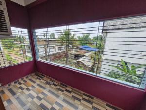 a room with two large windows and a balcony at Jorhat Homestay in Jorhat