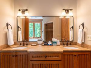 a bathroom with two sinks and a large mirror at Headwaters Hideaway in Elk Park +55 photos