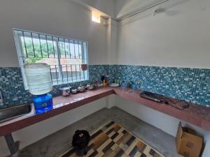 a kitchen with a counter with a window and a sink at Jorhat Homestay in Jorhat