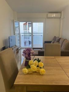 a bouquet of yellow roses on a wooden table at Marina Luka in Bar