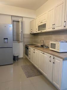 a kitchen with white cabinets and a stainless steel refrigerator at Marina Luka in Bar