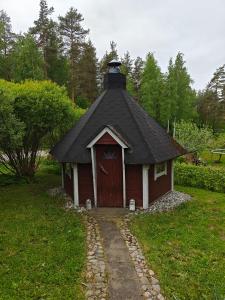 a small house with a black roof in the grass at Kottaraispari in Imatra