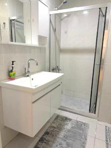 a white bathroom with a sink and a shower at King Suite SS0 in Istanbul +9 photos