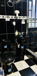 a bathroom with a black toilet and a sink at Hospedaje Rural Villa Sadais in Monguí +35 photos