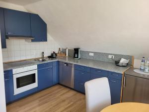 a kitchen with blue cabinets and a sink at Ferienwohnung Allgäu in Kißlegg