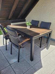 a wooden table and chairs on a patio at Ferienwohnung Allgäu in Kißlegg +17 photos