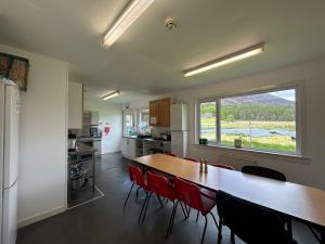 a kitchen with a long table and red chairs at The Bunkhouse in Applecross