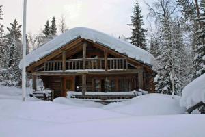 une cabane en rondins avec de la neige au-dessus dans l'établissement Hillankukka, à Äkäslompolo