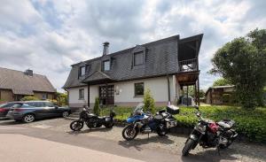 a group of motorcycles parked in front of a house at Ferienwohnung "Zum Pfadfinder" in Thalfang