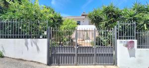 a gate in front of a house with palm trees at La grazia in qualche modo in Siniscola