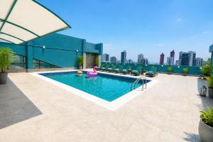 a swimming pool on top of a building with a city skyline at Al Manzil Hotel Bahrain in Juffair