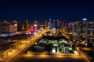 a city lit up at night with traffic at Al Manzil Hotel Bahrain in Juffair