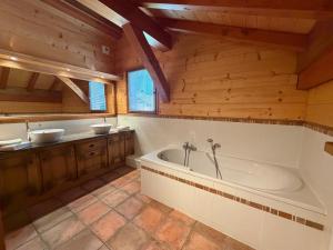 a large bathroom with a tub and two sinks at Chalet Pétérets in Samoëns +19 photos