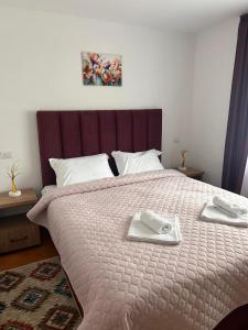 a bedroom with a large bed with two towels on it at Pensiunea ALDA in Suceviţa +38 photos