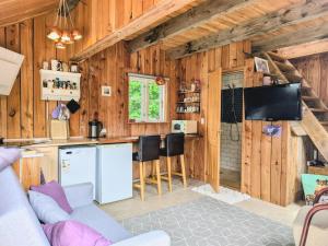 a kitchen and living room in a log cabin at Stevns Birkevang The Silo - Rural refuge in Faxe