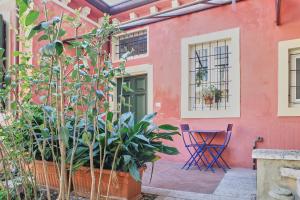 a pink house with a table and plants in front of it at Truly Verona in Verona