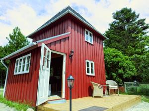 a red tiny house with a wooden deck at Stevns Birkevang The Silo - Rural refuge in Faxe