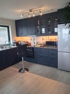 a kitchen with black cabinets and a white refrigerator at Fjordhytte-24 in Bøvågen +27 photos