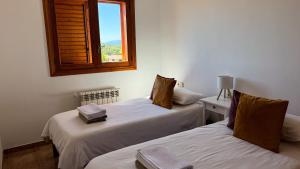 two beds in a room with a window at Sa Tanca in Pòrtol +19 photos