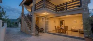 a house with a balcony with a table and a couch at Villa Nathanael in Pogradec