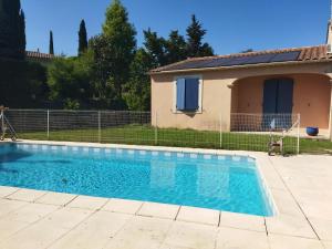 a swimming pool in front of a house at Chambres Tricastine et Venise in Saint-Paul-Trois-Châteaux