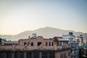 a group of buildings with mountains in the background at Famous House Kathmandu in Kathmandu