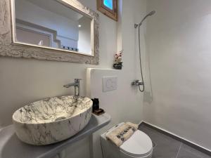 a bathroom with a large marble sink and a toilet at Ramos Wellside Apartments in Serifos Chora +40 photos