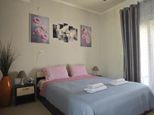 a bedroom with a bed with two towels on it at Elina House and Garden in Nikiti