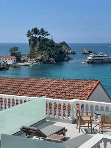 a balcony with a view of the ocean and a house at Olympic Apartments in Parga