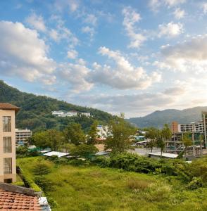 a view of a city with mountains in the background at Holiday House Kata & Karon Phuket Hotel in Kata Beach
