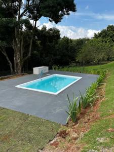 a swimming pool on top of a concrete driveway at Casa represa Piracaia in Piracaia