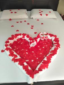 a heart made out of red hearts on a bed at Max Motel in Jaguariúna