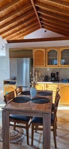 a kitchen with a wooden table with chairs and a tableasteryasteryasteryasteryastery at Vrisi House in Kiparission