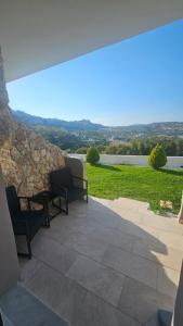 a patio with two chairs and a stone wall at Alma-Libre house 2 in Kefalos