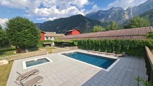 a swimming pool with chairs and mountains in the background at Maso Montel in Barco +9 photos