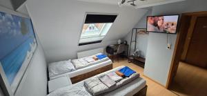 a small room with two beds and a flat screen tv at Sonnige Ferienzimmer WHV in Wilhelmshaven
