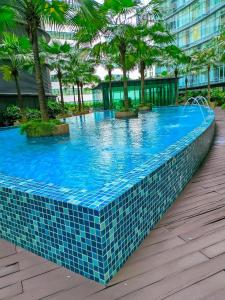 a swimming pool in a resort with palm trees at vortex Suites KLCC KL in Kuala Lumpur