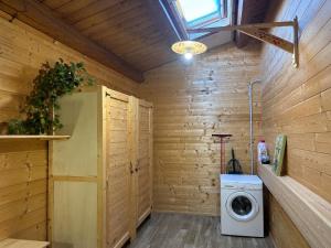 a washer and dryer in a room with wooden walls at Le scalette di Giocondo in Roio Piano +8 photos