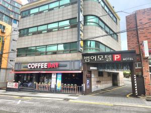 a building with a coffee shop on a city street at 범어사 범어호텔 in Ch'ŏngnyong-dong