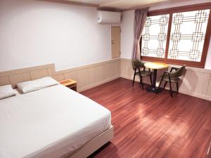 a bedroom with a bed and a table and chairs at 범어사 범어호텔 in Ch'ŏngnyong-dong