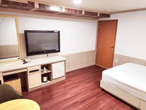 a room with a bed and a flat screen tv at 범어사 범어호텔 in Ch'ŏngnyong-dong